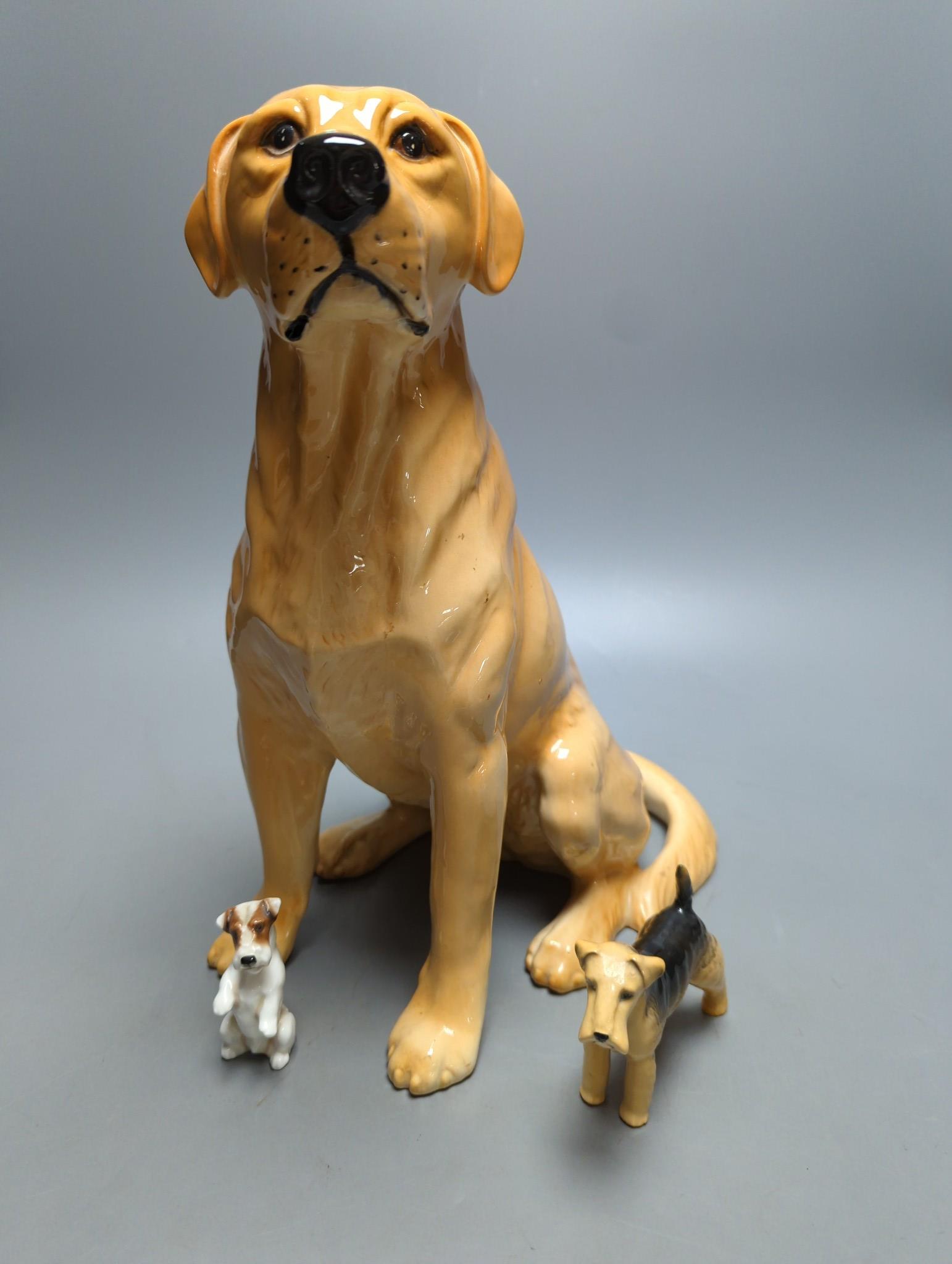 A large Royal Doulton figure of a seated Labrador (No. 2314), height 34cm, a small Beswick Airedale Terrier and another (3)